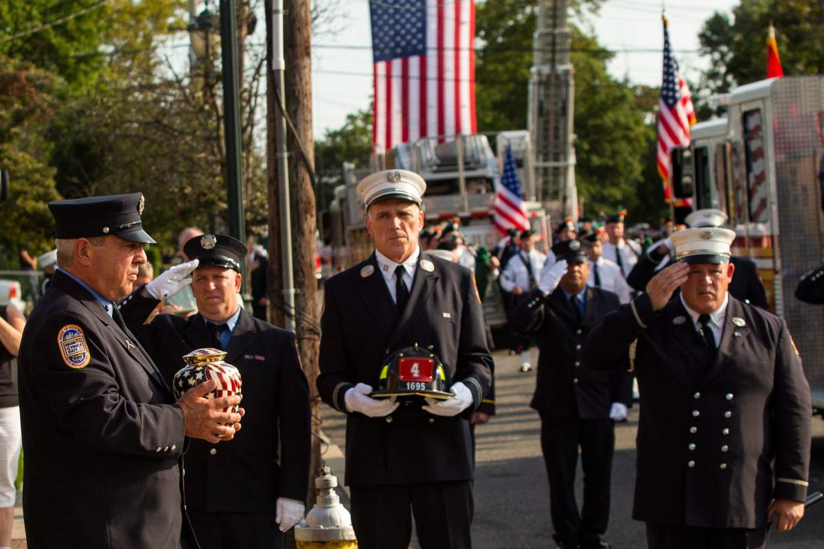 A New York Fire Department member, left, carries the remains of FDNY firefighter Michael Haub during the second funeral service for him in Franklin Square, N.Y. (AP Photo/Eduardo Munoz Alvarez)