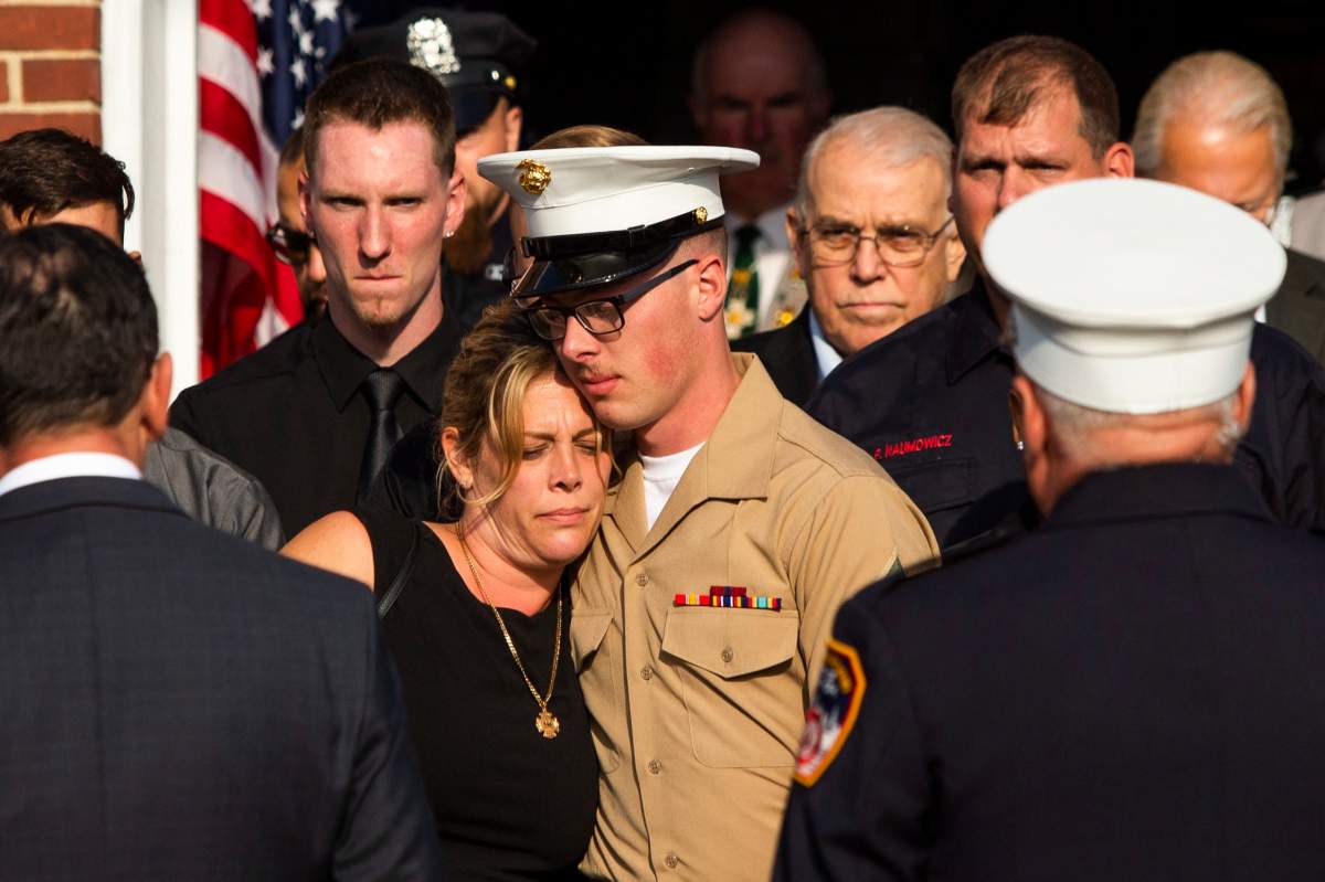 Erika Starke, left, is comforted by her son Michael Haub as they attend a second funeral service for New York Fire Department firefighter Michael Haub, in Franklin Square, N.Y. (AP Photo/Eduardo Munoz Alvarez)
