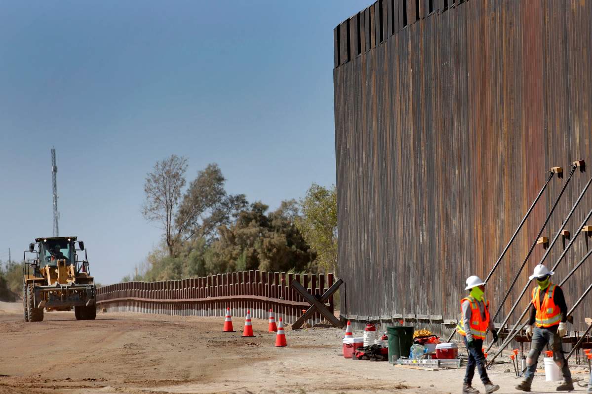 Government contractors erect a section of Pentagon-funded border wall along the Colorado River, Tuesday, Sept. 10, 2019 in Yuma, Ariz. (AP Photo/Matt York)