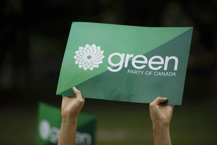 A supporter holds a sign for the Green Party of Canada in Toronto, Tuesday, Sept. 3, 2019.