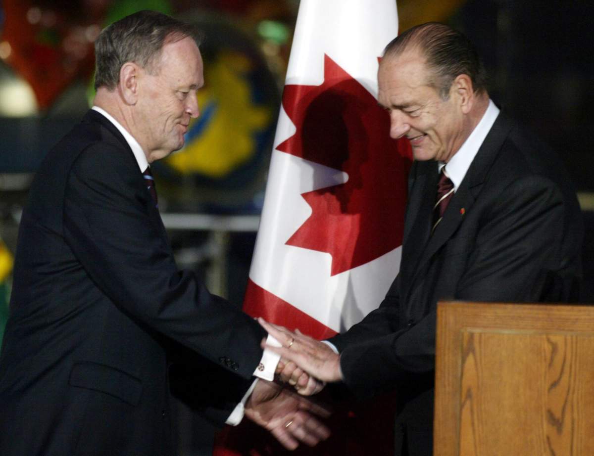 French President Jacques Chirac clasps hands with Canadian Prime Minister Jean Chretien during a ceremony opening an exhibit on the 400th anniversary of the shared history between Canada and France in Paris Tuesday, Dec. 8, 2003. THE CANADIAN PRESS/Tom Hanson