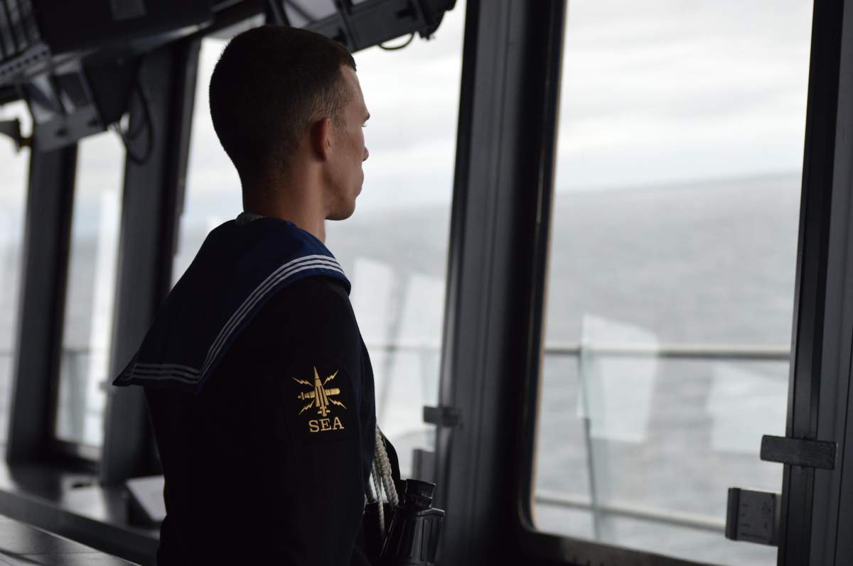 A Royal Navy sailor looks out from the deck of HMS Queen Elizabeth as it prepares to enter Halifax Harbour on Sept. 12, 2019.