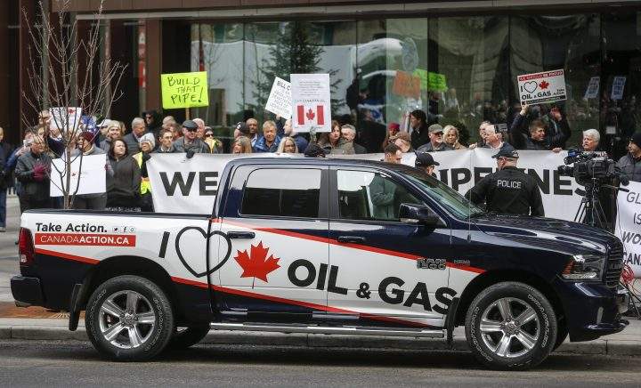 Pro-oil and gas supporters protest across the street as federal Finance Minister Bill Morneau speaks to the Economic Club of Canada about the 2019 federal budget in Calgary on March 25, 2019.