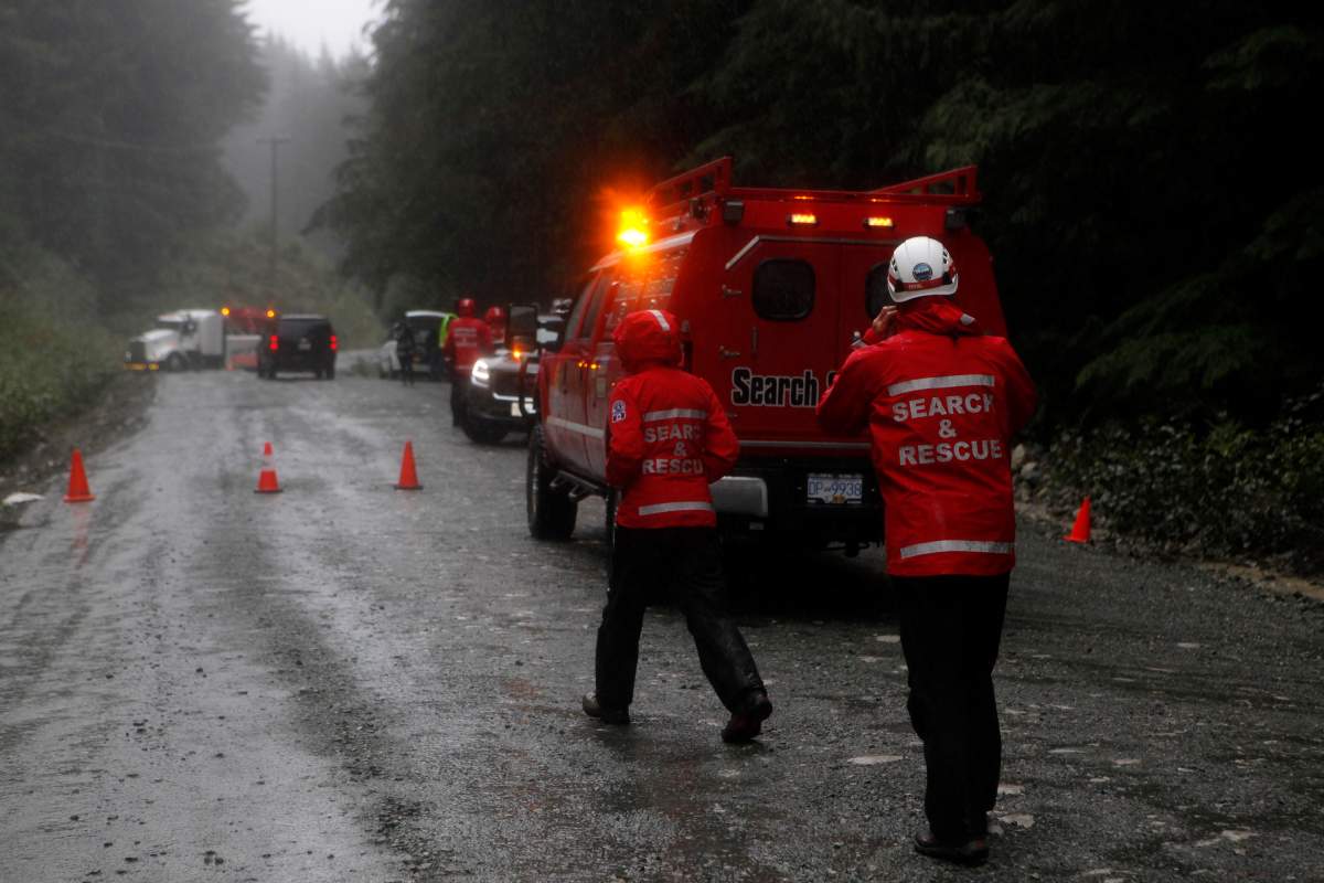 Search and rescue crews and RCMP help a tow truck crew remove a bus from the ditch of a logging road near Bamfield, B.C., on Saturday, Sept. 14, 2019.