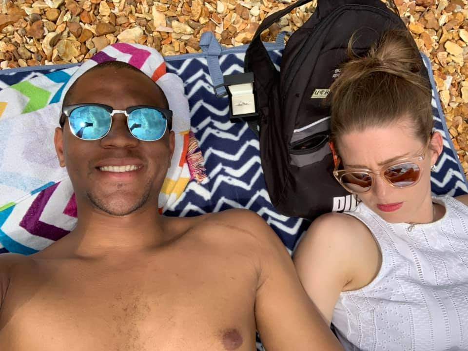 Edi Okoro, left, is shown with his girlfriend Cally Read, who is unaware of the engagement ring positioned beside her head.