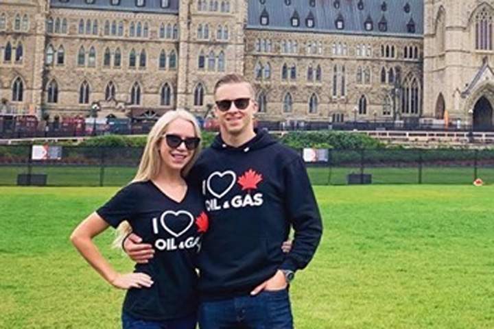 Chris Wollin, right, and his fiancée Mallory Hartviksen are shown at Parliament Hill wearing “I love Canadian oil and gas” shirts in September 2019. He claims security stopped him at Parliament over his shirt.