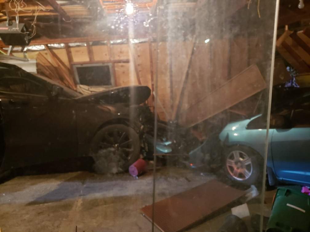 The SUV struck a car parked inside the attached garage.
