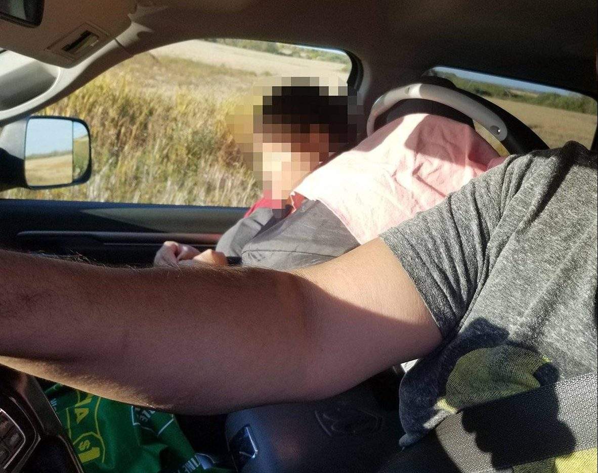 The car seat was balanced precariously on the console between the two front seats.