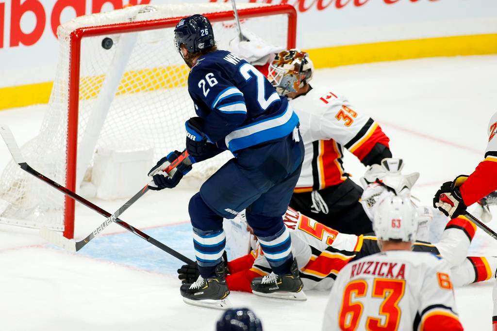 Winnipeg Jets' Blake Wheeler (26) scores on Calgary Flames goaltender Cam Talbot (39) during third period NHL pre-season action in Winnipeg on Sunday, Sept. 22, 2019. THE CANADIAN PRESS/Fred Greenslade.