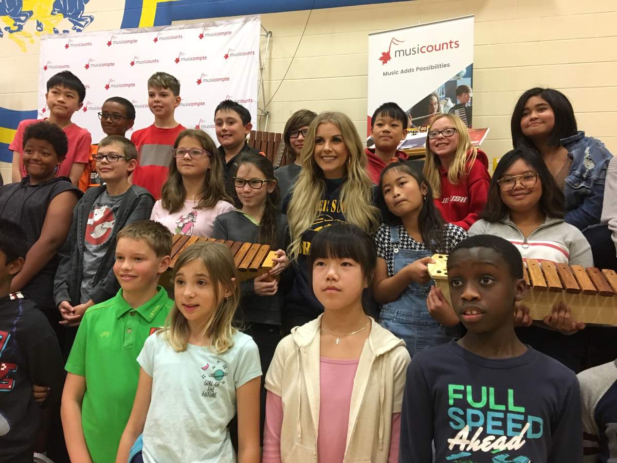 Lindsay Ell poses with students at Calgary's Father Scollen School after presenting the school with a $15,000 grant for musical instruments from the MusiCounts Band Aid program.