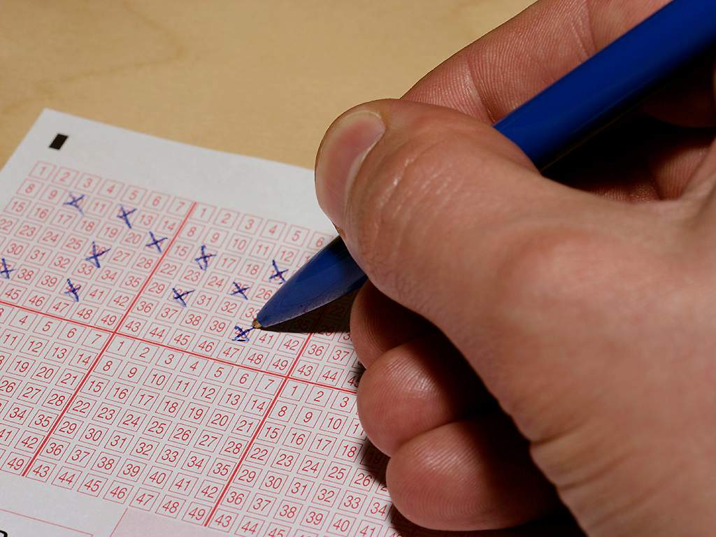 A man picks his numbers for a lotto ticket.