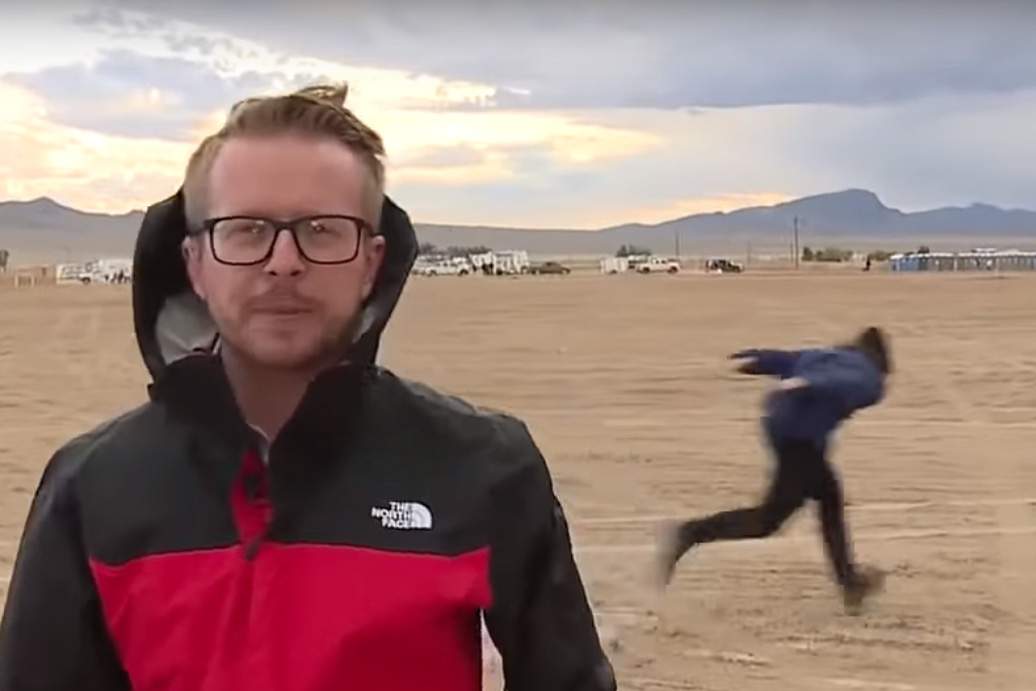 An alien enthusiast demonstrates a Naruto run, right, behind an ABC News reporter in Rachel, Nev., on Sept. 19, 2019.