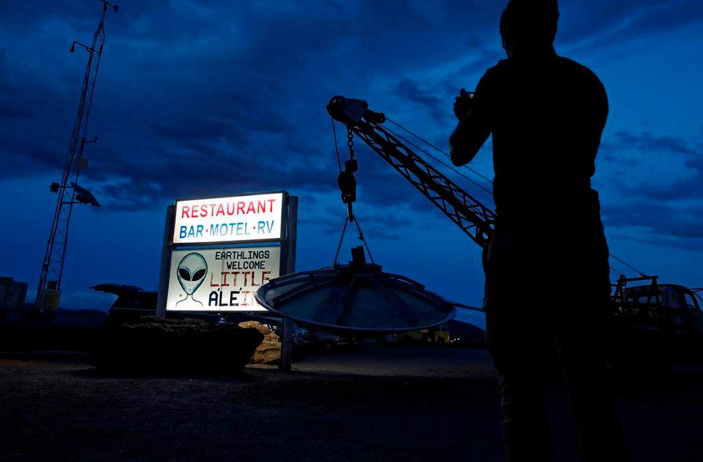 A man takes a picture of a sign at the Little A'Le'Inn during an event inspired by the "Storm Area 51" internet hoax, Thursday, Sept. 19, 2019, in Rachel, Nev.