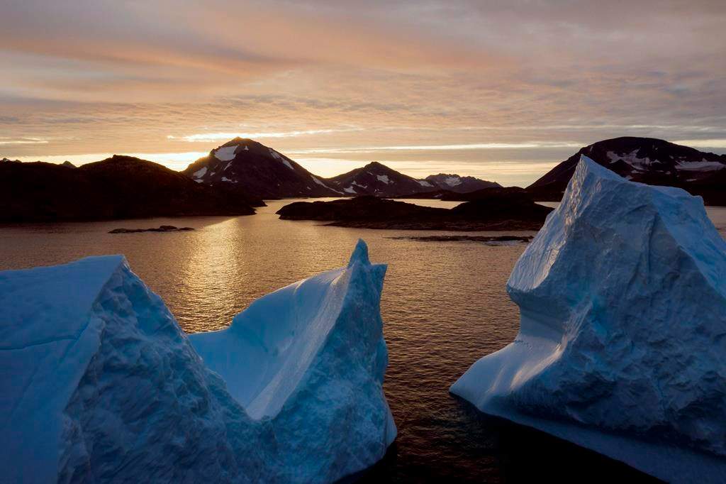 This early Friday, Aug. 16, 2019 file photo shows an aerial view of large Icebergs floating as the sun rises near Kulusuk, Greenland. Greenland has been melting faster in the last decade, and this summer, it has seen two of the biggest melts on record since 2012. A special United Nations-affiliated oceans and ice report released on Wednesday, Sept. 24, 2019 projects three feet of rising seas by the end of the century, much fewer fish, weakening ocean currents, even less snow and ice, and nastier hurricanes, caused by climate change.