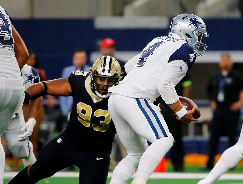 In this Nov. 29, 2018, file photo, Dallas Cowboys quarterback Dak Prescott (4) is pressured by New Orleans Saints defensive tackle David Onyemata (93) in the first half of an NFL football game, in Arlington, Texas.