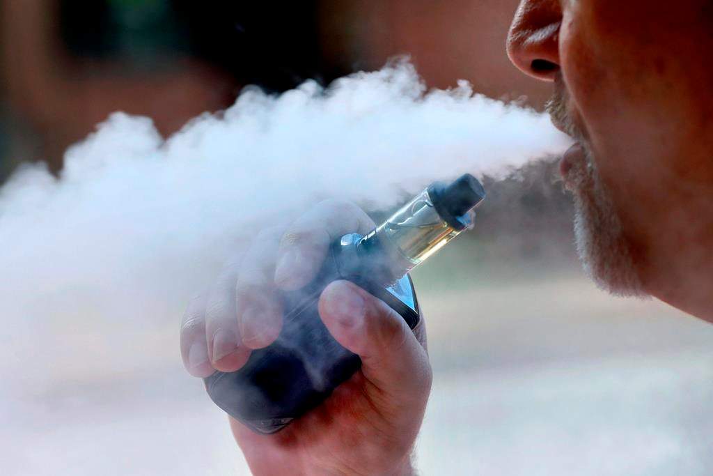 File image of man exhaling while smoking an e-cigarette.