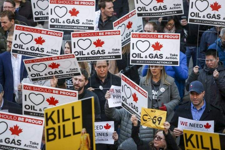 Pro-pipeline protesters gather and chant slogans outside a venue where federal Finance Minister Bill Morneau was speaking in Calgary on Nov. 27, 2018.