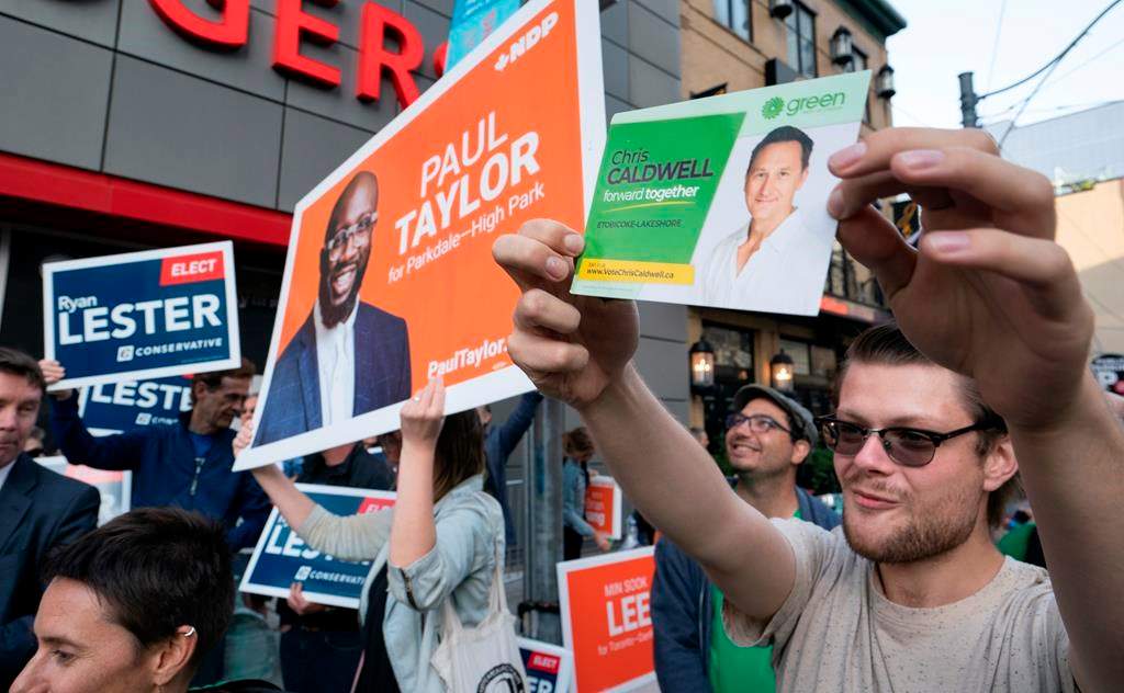 Supporters from various parties hold up campaign signs outside the studio of the first election debate in Toronto, on Thursday, Sept. 12, 2019. THE CANADIAN PRESS/Paul Chiasson.