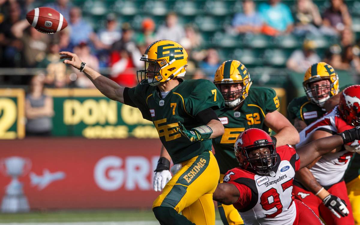 Calgary Stampeders Derek Wiggan (97) reaches for Edmonton Eskimos quarterback Trevor Harris (7) as he makes the throw during first half CFL action in Edmonton, Alta., on Saturday September 7, 2019.