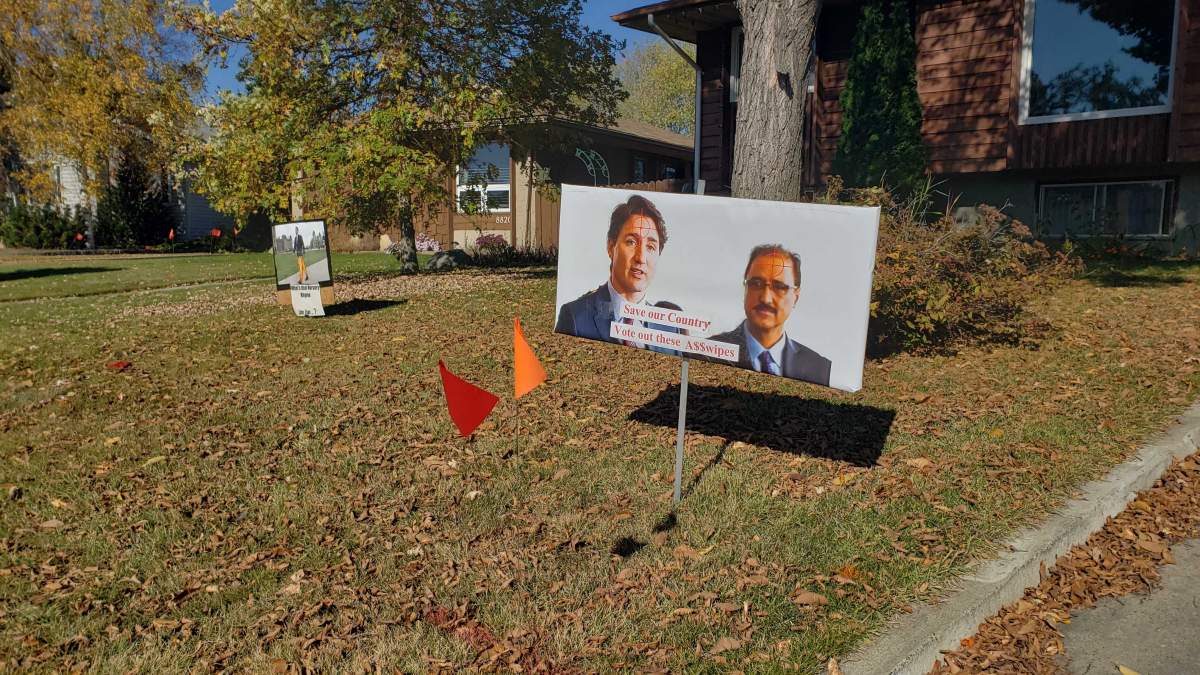 Two signs on a lawn in southeast Edmonton, with one showing Liberal leader Justin Trudeau and Edmonton Mill Woods candidate Amarjeet Sohi with crosshair targets on the foreheads, on Oct. 3, 2019.