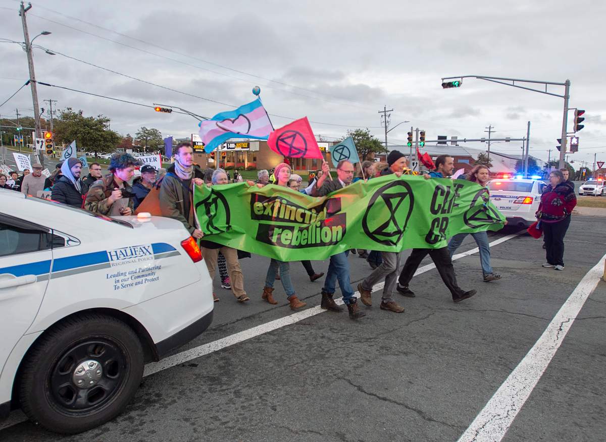 Members of Extinction Rebellion, protesting issues related to climate change, march to the Angus L. Macdonald Bridge in Dartmouth, N.S. on Monday, Oct. 7, 2019.