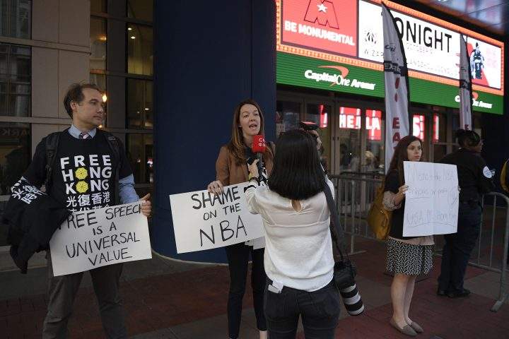 Activists hold signs outside Capital One Arena before an NBA preseason basketball game between the Washington Wizards and the Guangzhou Loong-Lions, Wednesday, Oct. 9, 2019, in Washington.