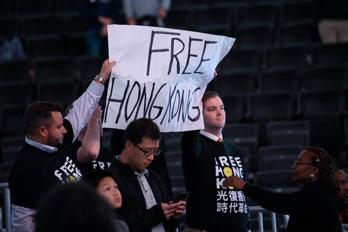 Activists hold up a sign before an NBA exhibition basketball game between the Washington Wizards and the Guangzhou Loong-Lions, Wednesday, Oct. 9, 2019, in Washington. 