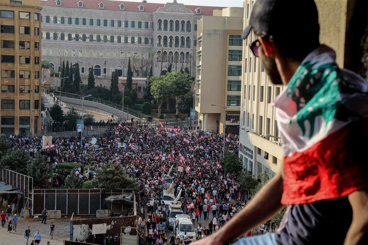 Protesters wave Lebanese flags shout anti-government slogans during a protest in downtown Beirut, Lebanon, 19 October 2019.