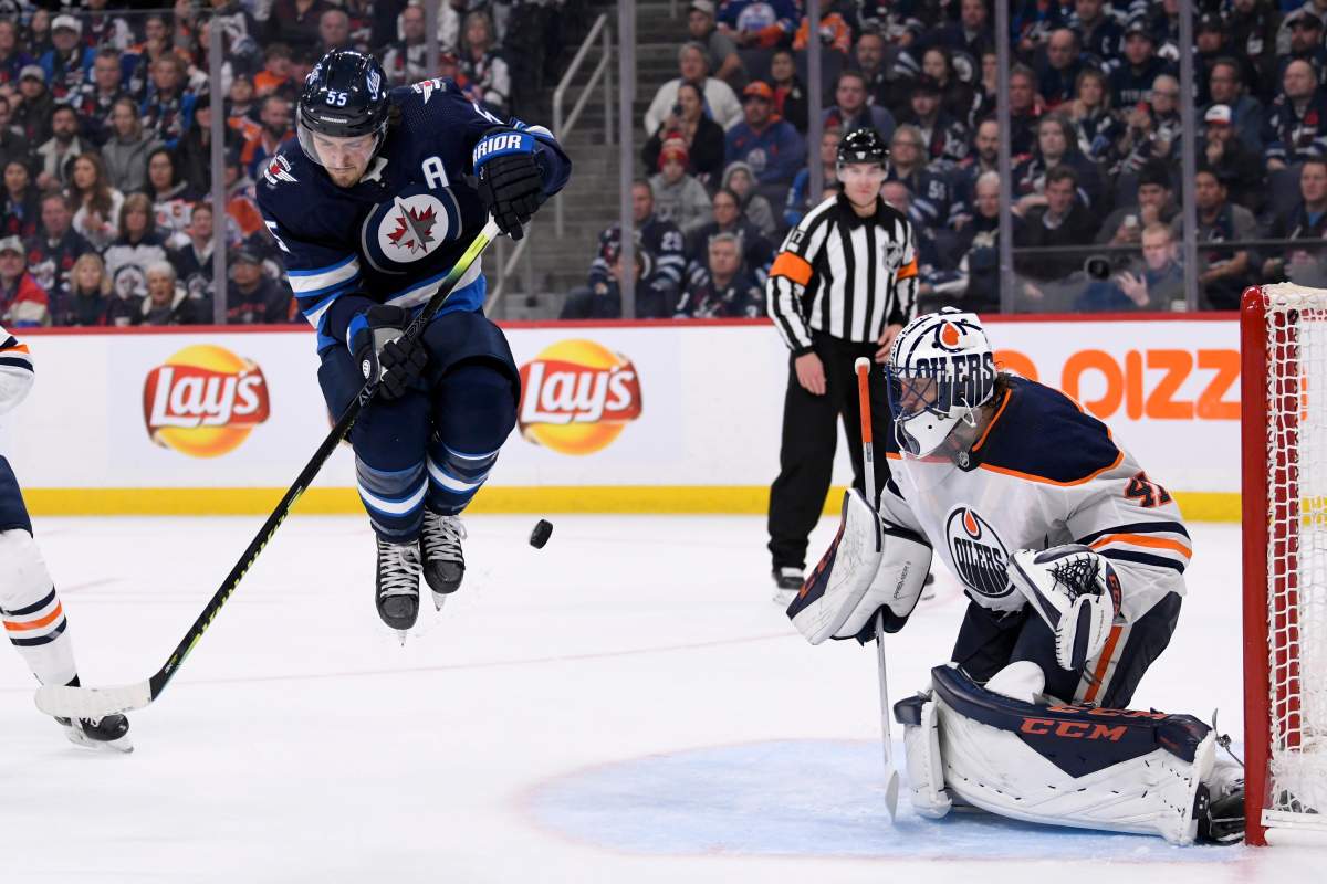 Winnipeg Jets' Mark Scheifele (55) jumps as puck is shot towards Edmonton Oilers' Mike Smith (41) during second period NHL action in Winnipeg on Sunday, Oct. 20, 2019. THE CANADIAN PRESS/Fred Greenslade.