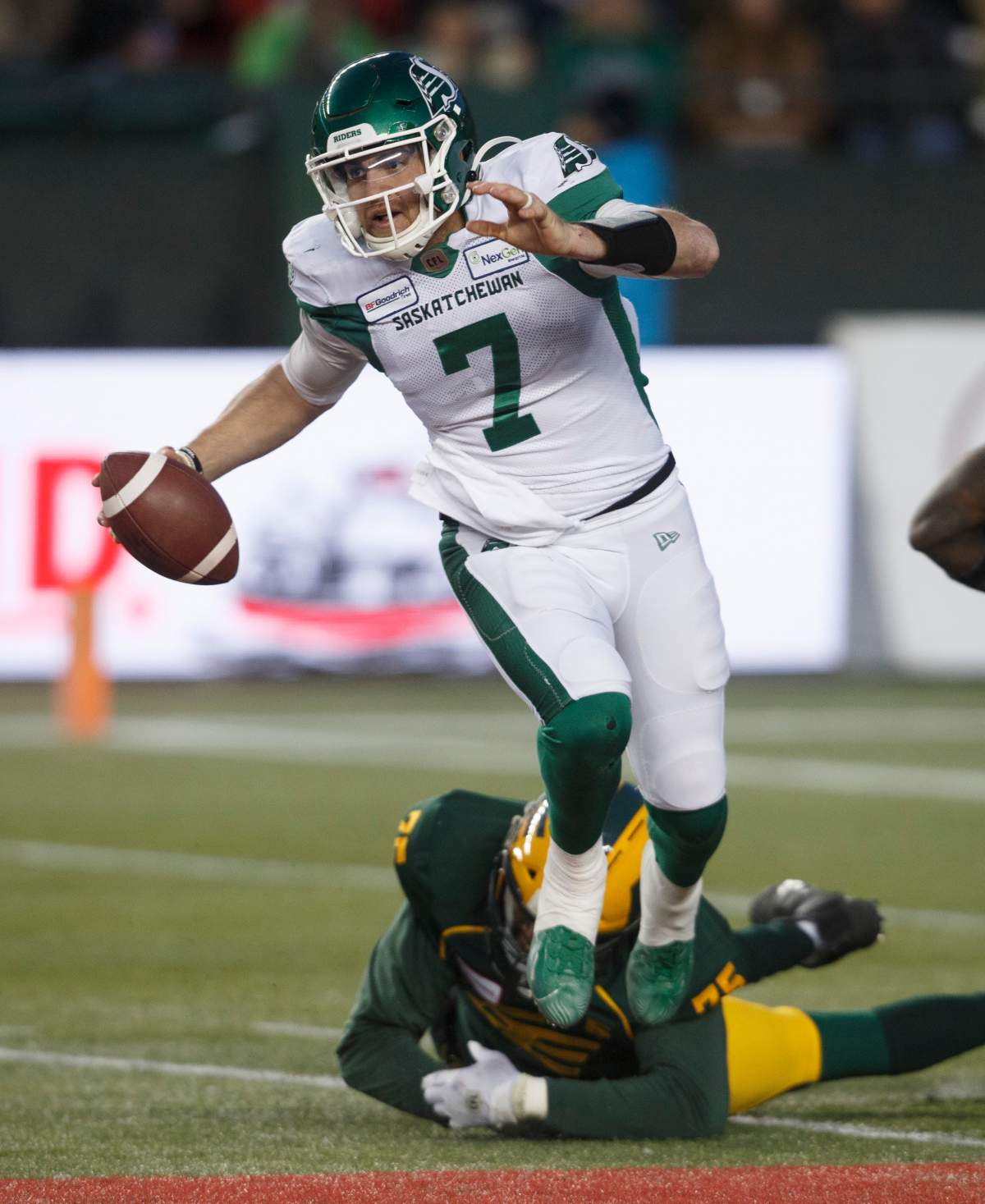 Saskatchewan Roughriders quarterback Cody Fajardo (7) dodges the tackle from Edmonton Eskimos' Nick Usher (75) during first half CFL action in Edmonton, Alta., on Saturday October 26, 2019.