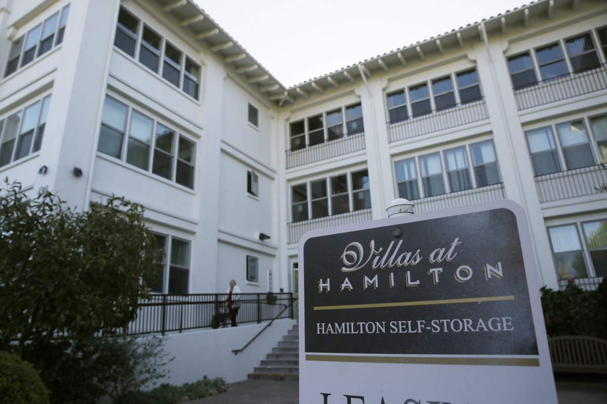 A woman makes her way out of the Villas at Hamilton housing complex Wednesday, Oct. 30, 2019, in Novato, Calif., where many low income seniors were stranded in the dark during the power blackouts.