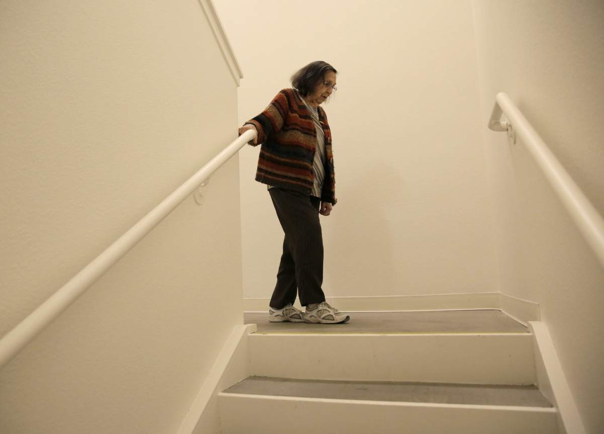 Helen Wagar, who is in her 80s, walks over the spot in a stairway where she fell over another woman who was laying in the dark during the recent power blackouts at the Villas at Hamilton housing complex for low income seniors Wednesday, Oct. 30, 2019, in Novato, Calif.