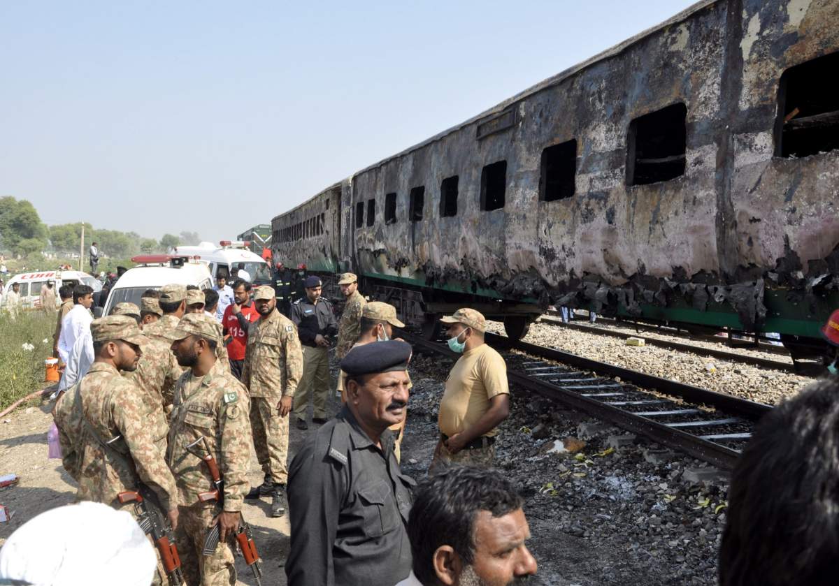 Pakistani soldiers and officials examine a train damaged by a fire in Liaquatpur, Pakistan, Thursday, Oct. 31, 2019. A massive fire engulfed three carriages of the train traveling in the country’s eastern Punjab province (AP Photo/Siddique Baluch)