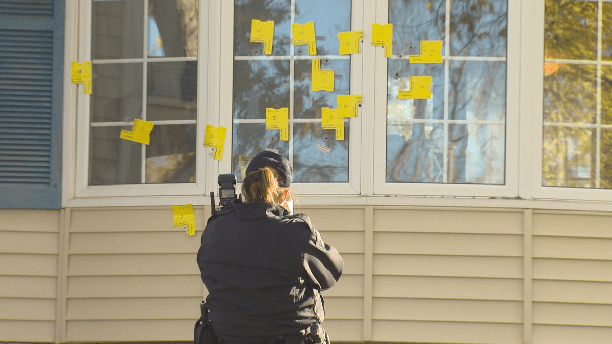 An RCMP officer photographs the scene of a drive-by shooting in Riverview, N.B., on Oct. 24, 2019