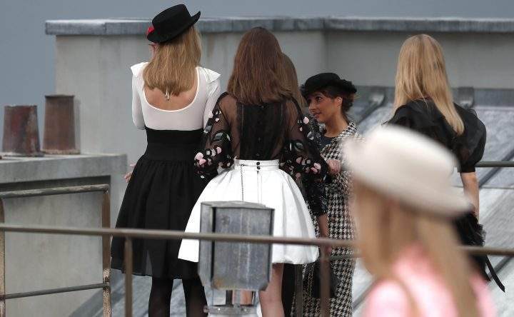 Models attempt to prevent French comedian Marie Benoliel from entering the backstage area after she leapt onto the catwalk during the Paris Fashion Week in Paris, France, on Oct. 1, 2019.