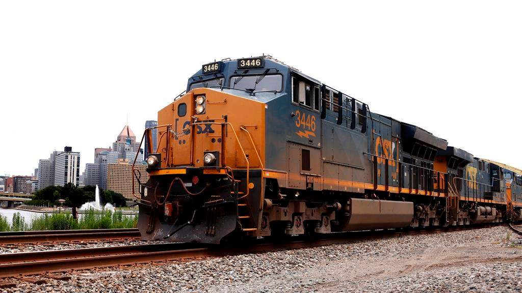 FILE - In this June 24, 2019, file photo, a CSX freight train rolls past downtown Pittsburgh. The biggest U.S. freight railroads appear ready to renew their push to reduce their crews to one-person from the current two-man operation used at major railroads now. Eight U.S. railroads have filed a federal lawsuit against the union that represents rail conductors to force the SMART union to negotiate about crew sizes during the next round of contract talks that starts in November. (AP Photo/Gene J. Puskar, File).