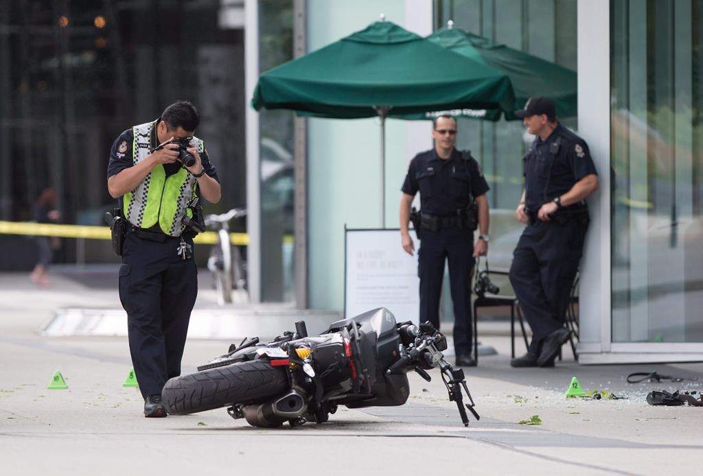 A police officer photographs a motorcycle after a female stunt driver working on the movie "Deadpool 2" died after a crash on set, in Vancouver, B.C., on Monday August 14, 2017. British Columbia's workplace safety agency says multiple failures of a production company contributed to the death of a stunt performer on the set of “Deadpool 2.”.