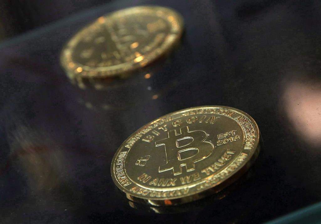 Bitcoin displayed next to a Bitcoin ATM in Hong Kong. Bitcoins are a popular a decentralized digital currency.