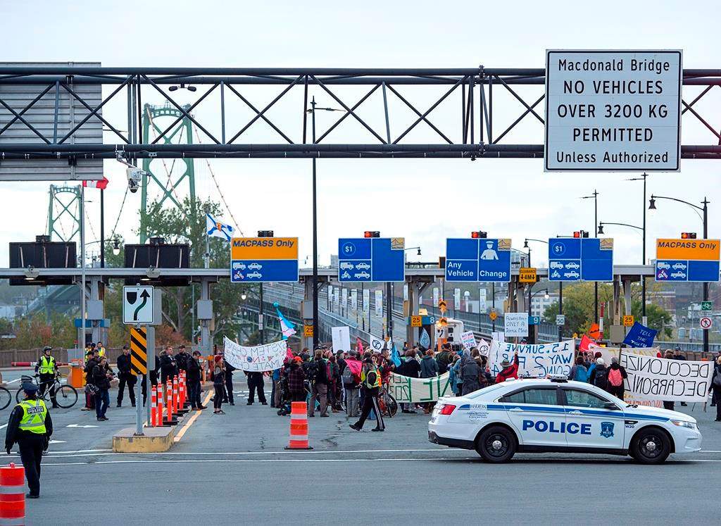 Members of Extinction Rebellion, protesting issues related to climate change, gather at the Angus L. Macdonald Bridge in Dartmouth, N.S. on Monday, Oct. 7, 2019.