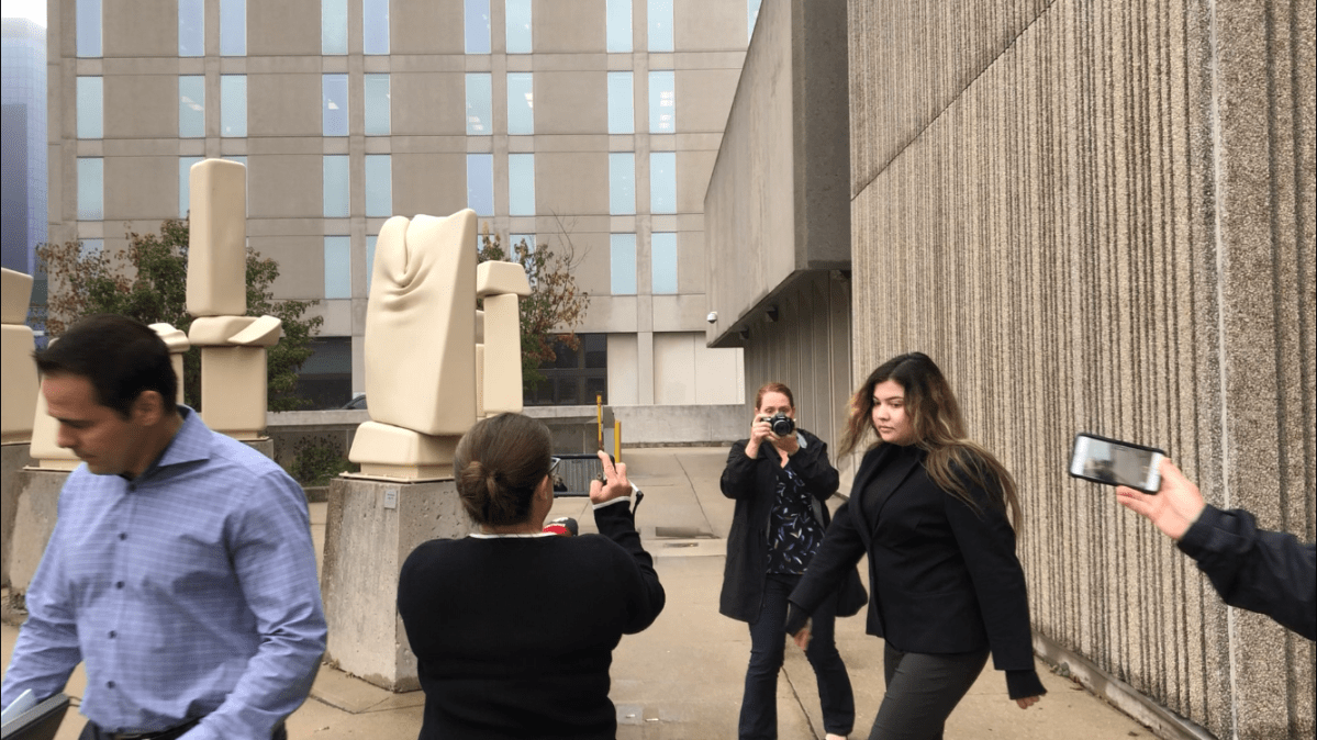 Daniella Leis, 23, is photographed by media as she leaves a London, Ont., courthouse on Oct. 2, 2019.