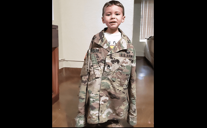 Omairis Taylor’s son Luke is pictured trying on her military uniform.