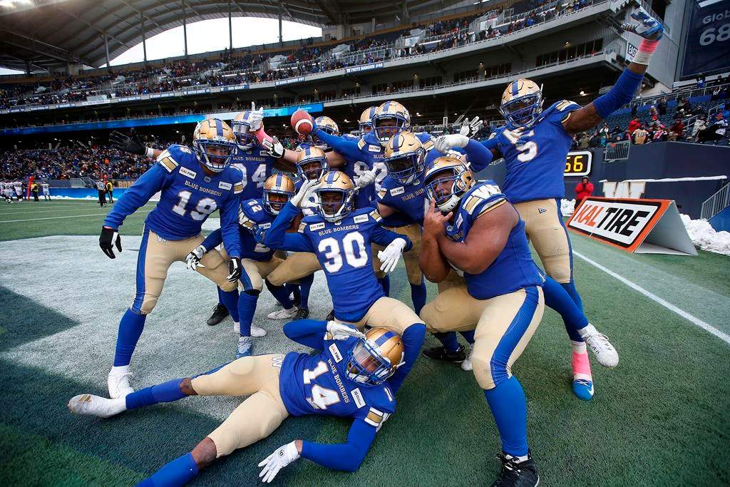 Winnipeg Blue Bombers' Nick Taylor (25), holding ball, and teammates celebrate his interception and touchdown during the second half of CFL action against the Montreal Alouettes, in Winnipeg, Saturday, Oct. 12, 2019.