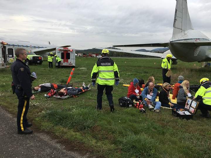 Emergency crews look after people who pretend to be injured during the mock plane crash exercise at YLW on Thursday morning.