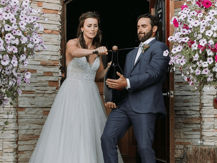 Kelsey Serwa eyes where she’s going to cut the top off a champagne bottle during her wedding last month.