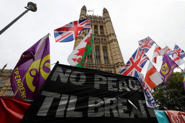 Various flags and banners fly in front of Parliament in London, Friday, Oct. 25, 2019. Politicians in Britain and the European Union seem to be looking to each other to break the Brexit deadlock.
