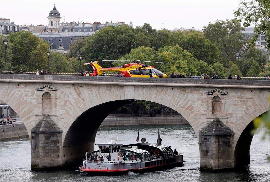 A helicopter is parked on the Pont Marie bridge after an incident at the police headquarters in Paris, Thursday, Oct. 3, 2019. (AP Photo/Kamil Zihnioglu)