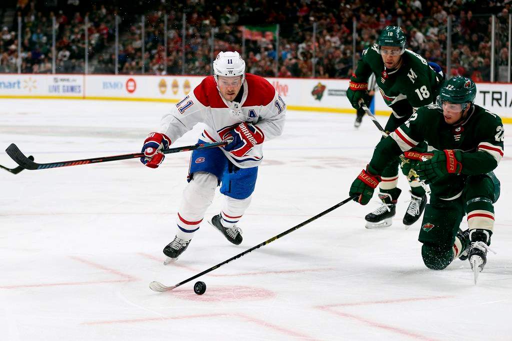 Minnesota Wild's Kevin Fiala (22) tries to gain control of the puck against Montreal Canadiens' Brendan Gallagher (11) in the second period of an NHL hockey game Sunday Oct. 20, 2019, in St. Paul, Minn.