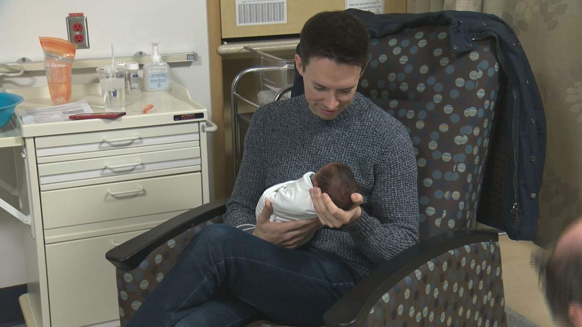 New parent Tom Clapperton, holding baby Ethan, says that the NICView cameras have been a huge comfort to him and his family.