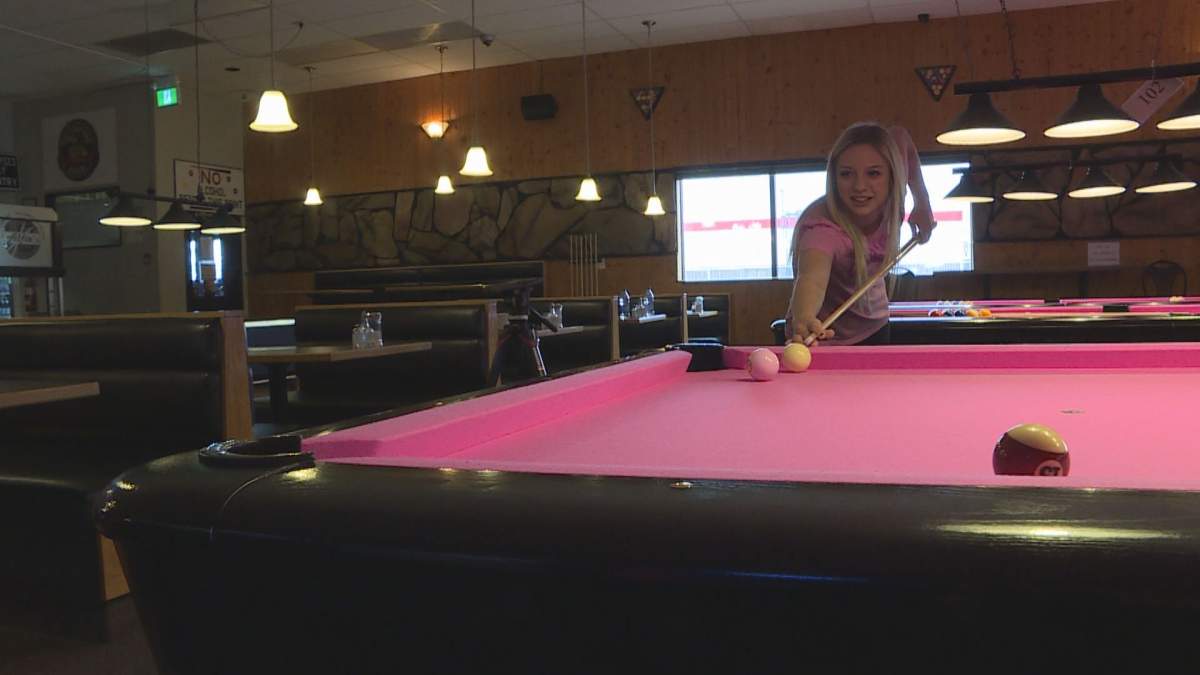 Bartender, Cassandra Cvican shooting pool at Alfie’s Restaurant.