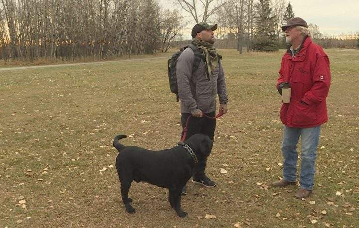 Veteran Damian Robertson (left) talks to Steve Critchley, founder of Can Praxis, at a walk for veterans in Calgary on Saturday, Oct. 19, 2019.